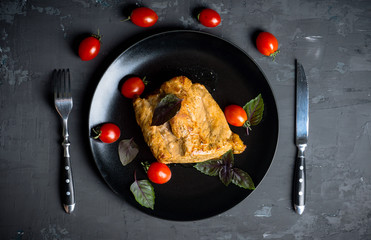 Roasted pork on the black plate. Shallow depth of field.