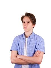 Serious young man. Portrait of handsome teen boy keeping arms crossed, isolated on white background