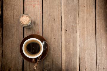Top view of a red cup of hot coffee put on a wooden table.Vintage tone with copy space.
