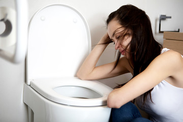 Young woman voimiting in the bathroom