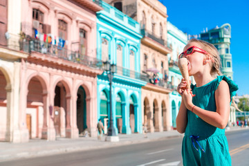 Adorable little girl eating ice-cream in popular area in Old Havana, Cuba. Portrait of cutiest kid...