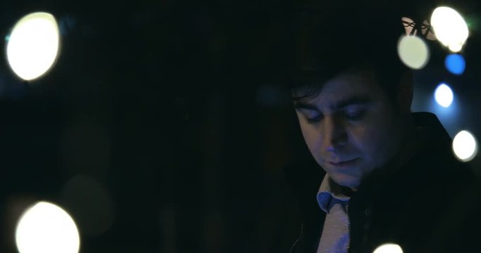 A man is looking downwards. The camera pans from left to right.