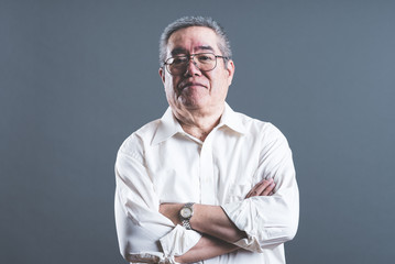 腕を組んでいるシニア男性