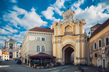 Fototapeta na wymiar Basilian Gates to the Church oh Holy Trinity and Church of St. Teresa on background. Vilnius, Lithuania.