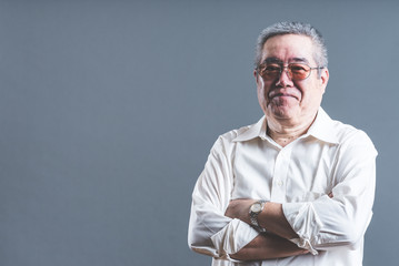 腕を組んでいるシニア男性