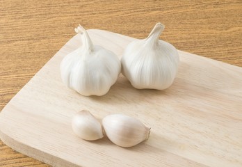 Garlic Bulbs and Garlic Cloves on Wooden Cutting Board