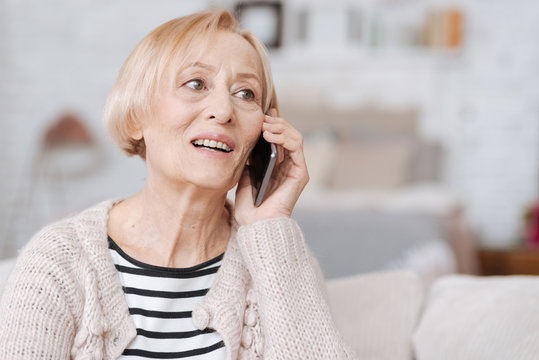 Cheery elderly woman calling her friend