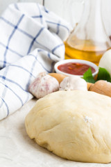 Dough and ingredients for pizza close-up on a white background.