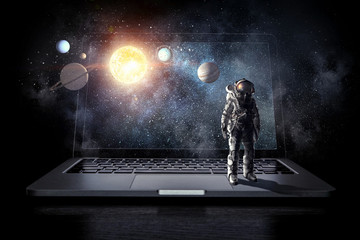 Space explorer and laptop. Mixed media