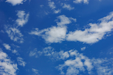Beautiful deep blue sky with white diagonally clouds at sunny day. Abstract natural background with thick fluffy clouds