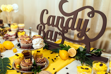Holiday candy bar. Candy bar served with cupcakes with chocolate and lemon cream on metal stand