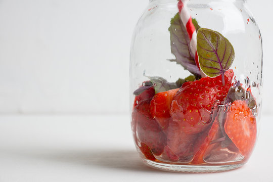 Empty jar from cocktail with strawberry and basil. Shallow depth of field.