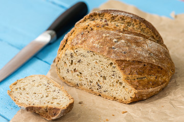 Sliced healthy round black bread on the table with knife