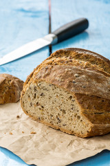 Sliced healthy round black bread on the table with knife