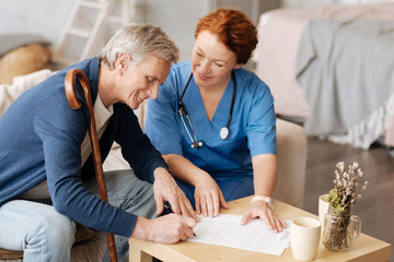 Charming delighted mature man signing the contract