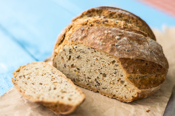 Sliced healthy round black bread on the table with knife