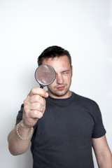 A man looks in a magnifying glass