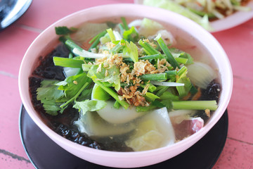 Vegetable soup with tofu in white bowl.