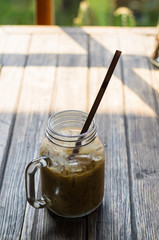 Straw in glasses of coffee  put on wooden table