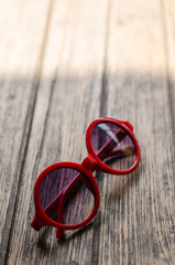 Sunglasses red color on wooden table