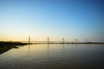 Fototapeta premium River view with Nhat Tan bridge in Hanoi at sunset
