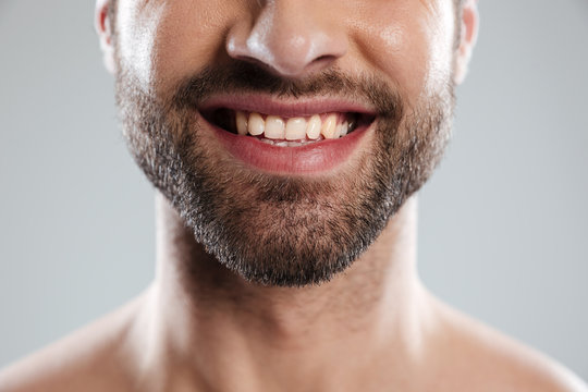 Cropped image of a laughing mans face with naked shoulders