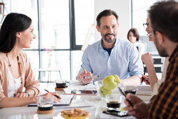 Cheerful busy smiling workers having conversation