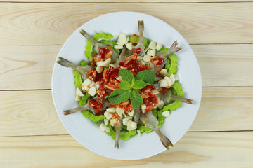 Spicy shrimp salad with fish sauce in white dish.