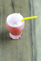Strawberry juice in Glass on wooden table floor.