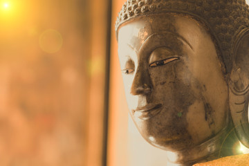 close up face on buddha head statue with Bokeh background