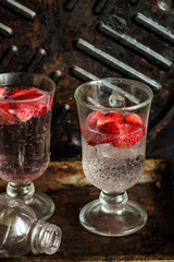 Strawberry slices with soda and ice in a transparent glass