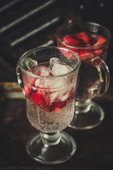 Strawberry slices with soda and ice in a transparent glass