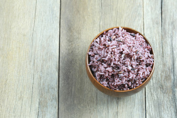 Organic Rice berry in wooden dish on wood background.