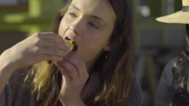 Closeup Of Woman Taking First Bite Of Her Taco, She Savors It 