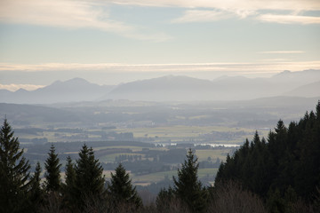 Sunrise in the green valley with mountains on background dramatic foggy sky and clouds.