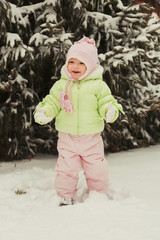 Funny little girl having fun in beautiful winter park during