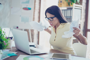 Bad mood. Young angry businesswoman is casual clothes and glasses is tired from work in the office,...