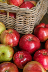 basket with red ripe apples on a brown wooden table