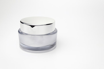 white and silver cosmetic jar on a white background