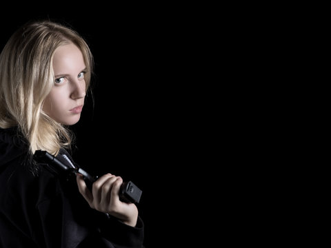 serious girl with gun on black background with copy space
