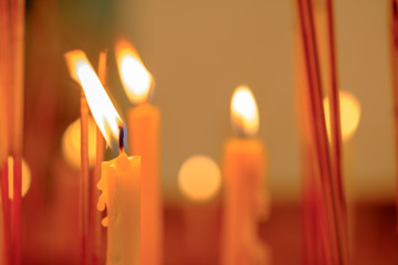 Many candle flames glowing in the night, create a spiritual atmosphere.