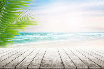 Empty wooden table and palm leaves with party on beach blurred background. Concept Summer, Beach, Sea, Relax, Party.