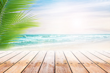 Empty wooden table and palm leaves with party on beach blurred background. Concept Summer, Beach, Sea, Relax, Party.