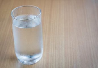 Glass of drink water on wooden table,selective focus.
