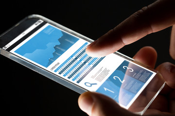 close up of hand with business chart on smartphone