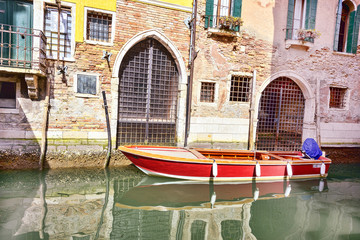 Red boat Venice scenic old streets water canal. Italian Lagoon