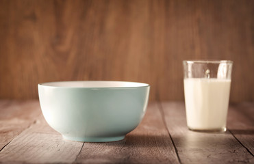Blue bowl and a cup of milk on a wooden table