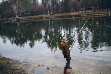 Young fisherman catches a fish on lake