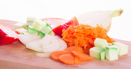 vitamin vegetarian set, zucchini, tomato, carrot, onion chopped for cooking on wooden cutting Board isolated on white background