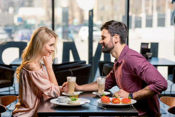 side view of couple in love having lunch in restaurant together